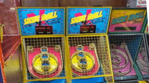 Two vintage skee-ball arcade machines with colorful designs.