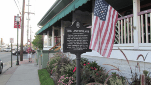 Historical marker outside The Anchorage with an American flag.