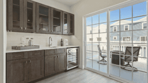 Modern kitchen with dark wood cabinets and glass door leading to balcony.