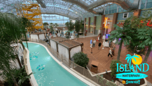 Indoor water park with a lazy river and people walking.