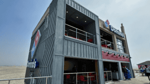Modern gray building with metal railings and outdoor seating.