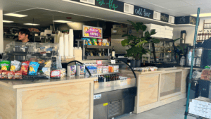 A modern coffee shop counter with a colorful menu and various drink options.