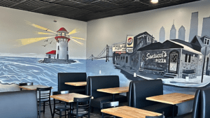 Interior of a pizza restaurant with nautical-themed wall art.