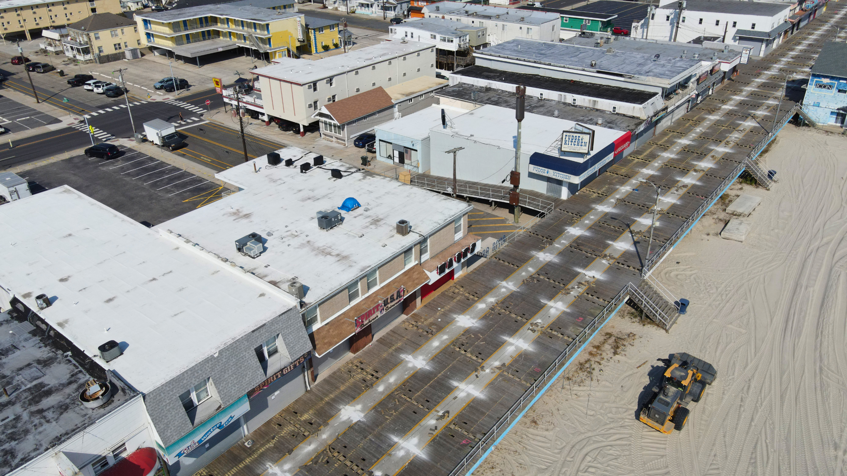 Aerial view of a small commercial area with flat-roofed buildings and a street.