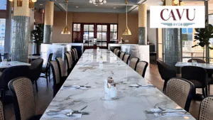Long marble table set for a meal in a spacious dining area.