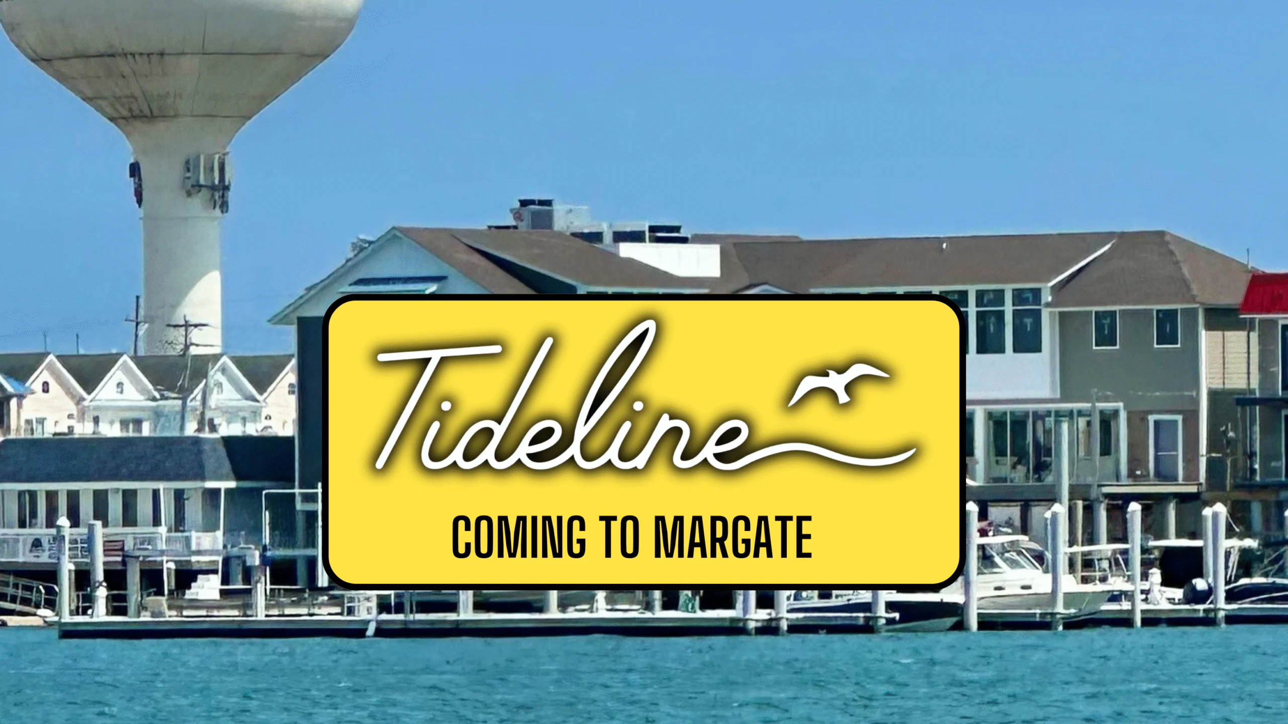 A yellow sign reading 'Tideline Coming to Margate' by the water.