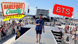 Man walking on stage at music festival.