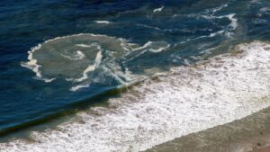 Ocean waves creating swirling foam pattern.