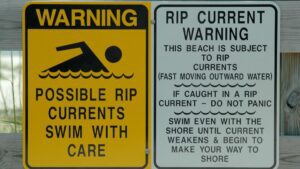 Warning signs about rip currents at beach.